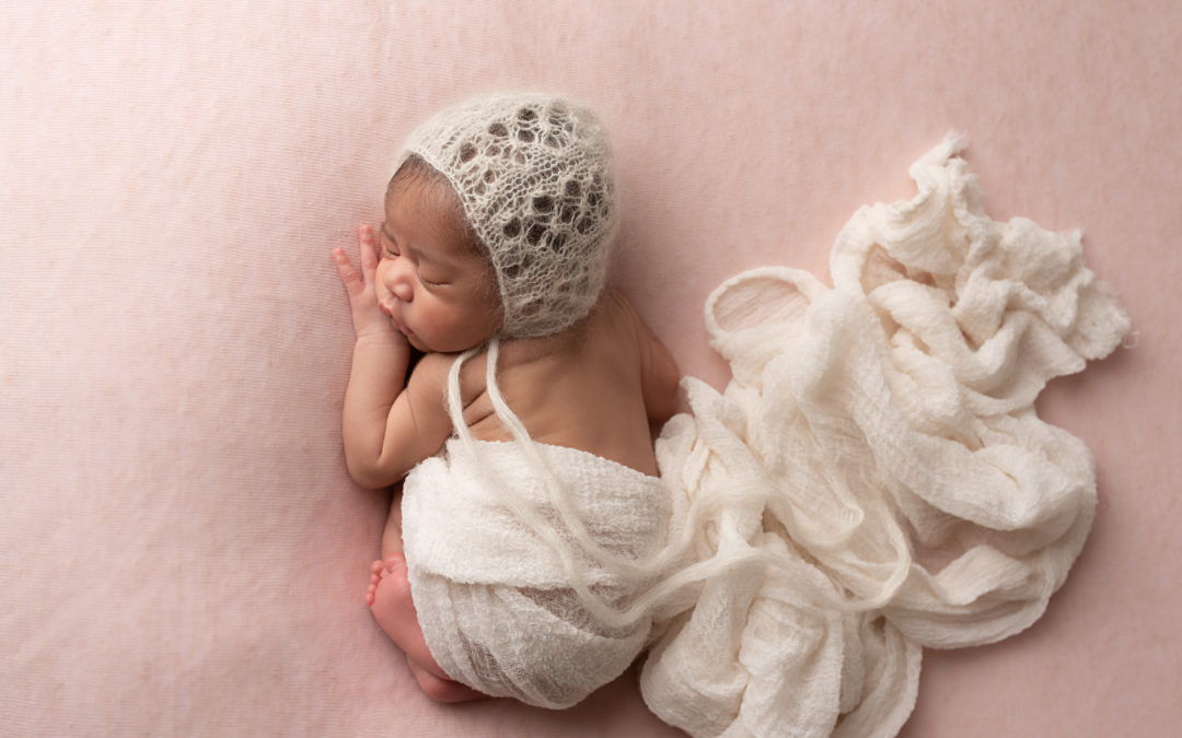 Newborn girl photographed on pink